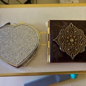 Two pocket mirrors with decorative covers.
